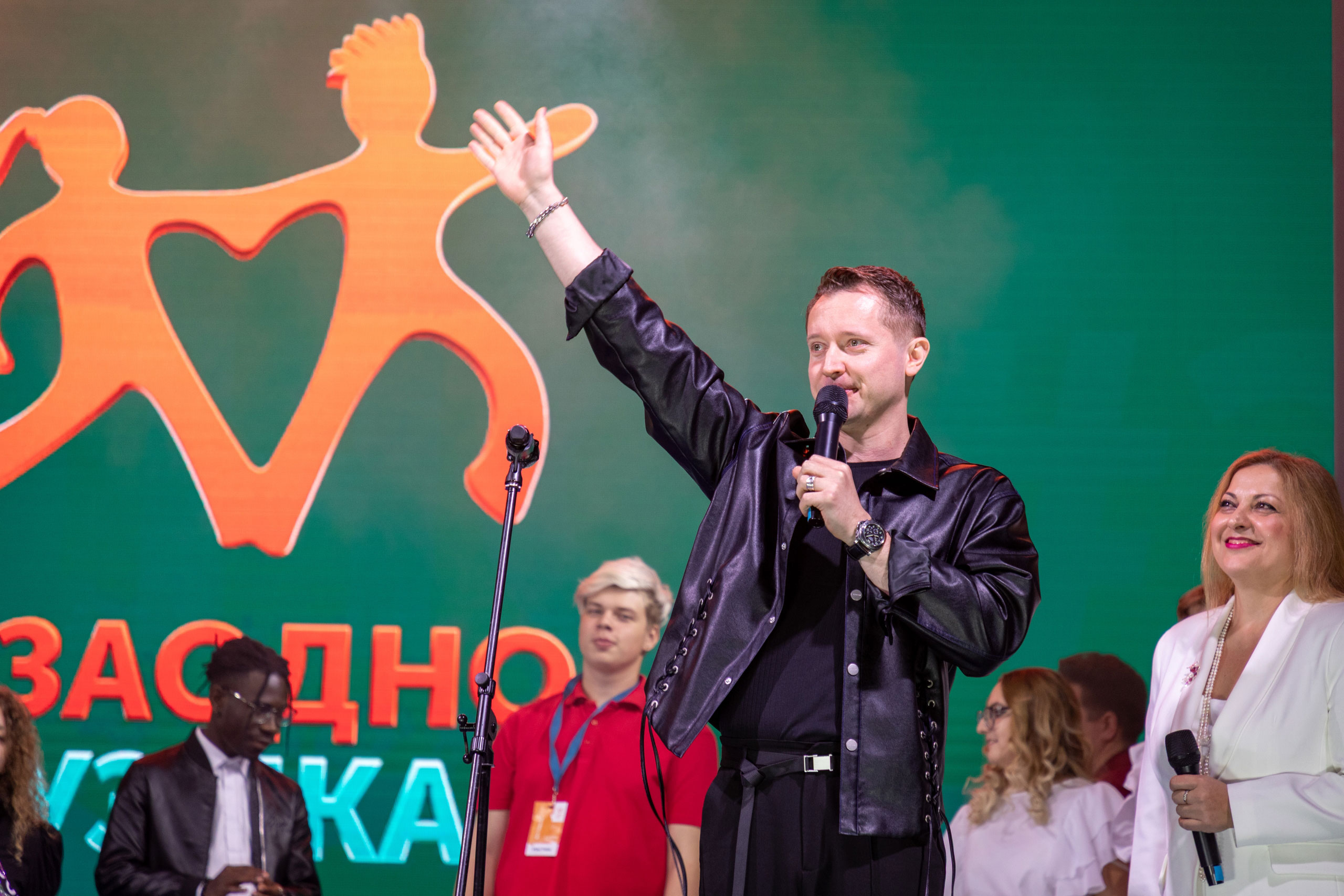 На изображении Ведущий выступает на сцене во время инклюзивного культурного мероприятия